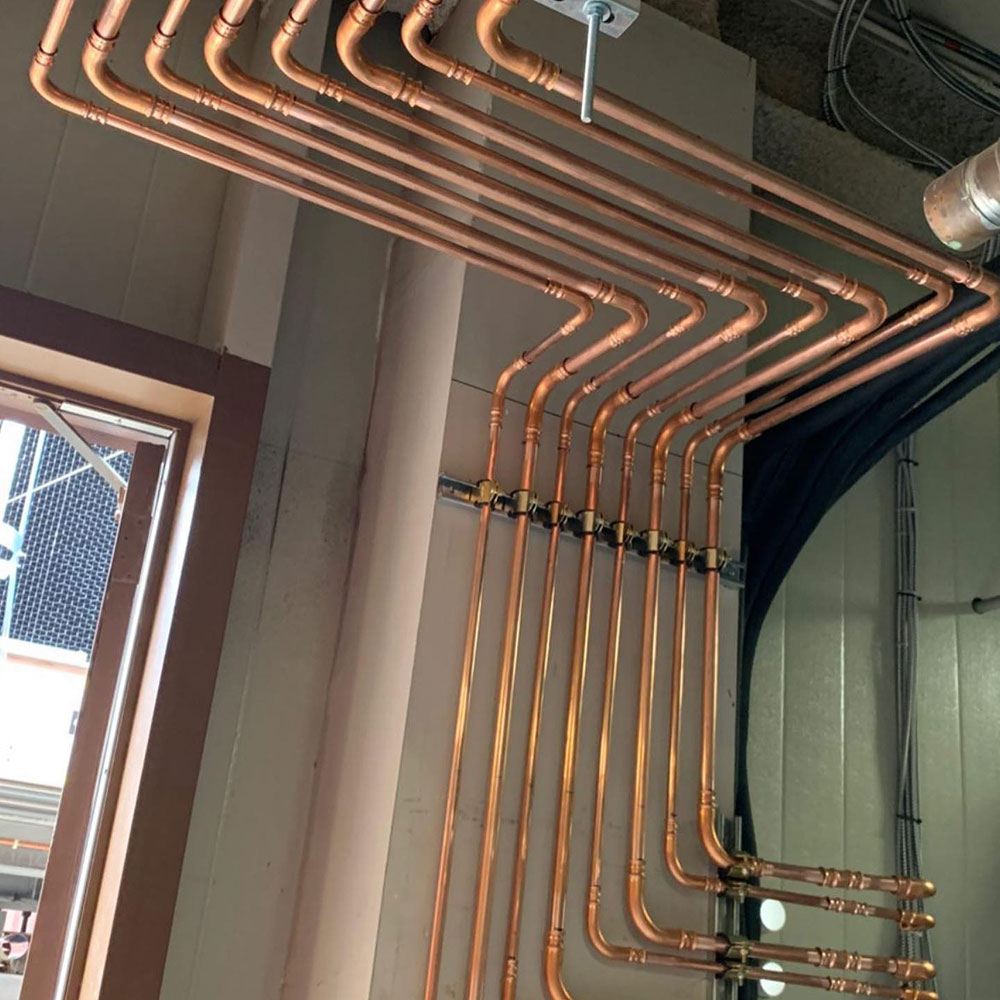 Contractor using RLS press tool on rooftop HVAC system at commercial building